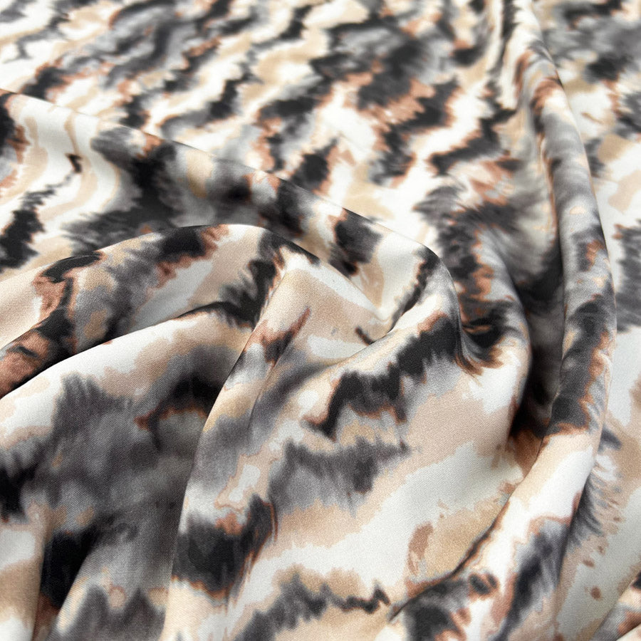 Printed viscose poplin with an abstract ivory, grey and brown pattern, draped to show its texture